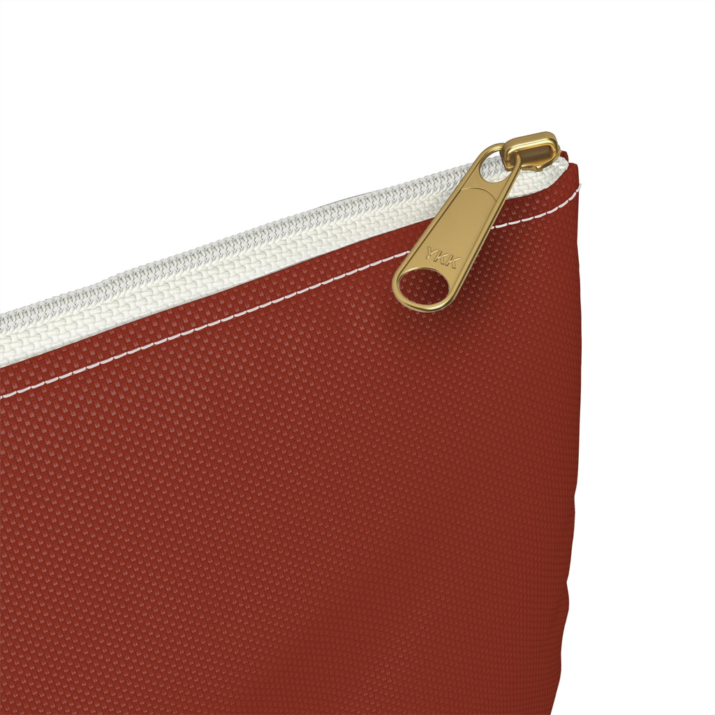 Close-up of a textured red zippered pouch with a gold-tone metal zipper pull and white zipper tape, shown on a plain white background.