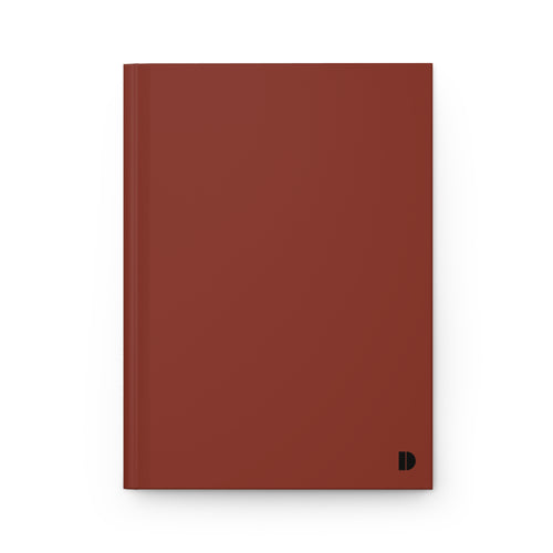A minimalist hardcover notebook in a matte terracotta red color, featuring a small black monogram logo in the bottom right corner, set against a clean white background.
