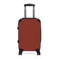 A hard-shell hardside suitcase in a brick red color, featuring a telescoping handle extended upwards and four spinner wheels, shown against a plain white background.