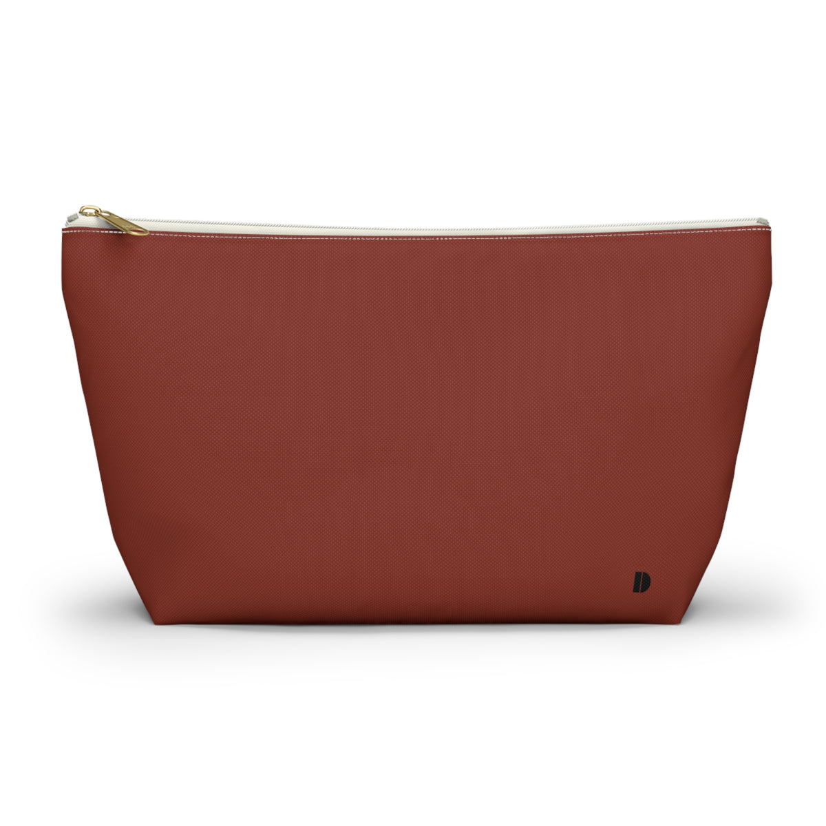 A terracotta red canvas cosmetic pouch with a gold zipper and a small black monogram logo on the bottom right, set against a plain white background.