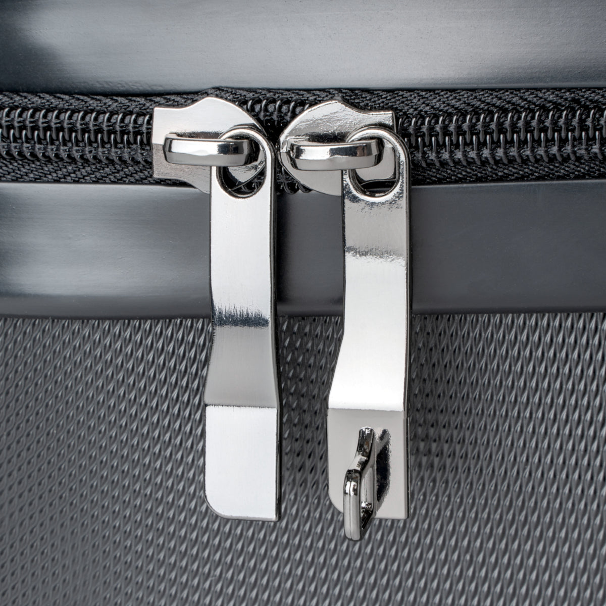 Close-up of a silver zipper pull on a textured gray surface