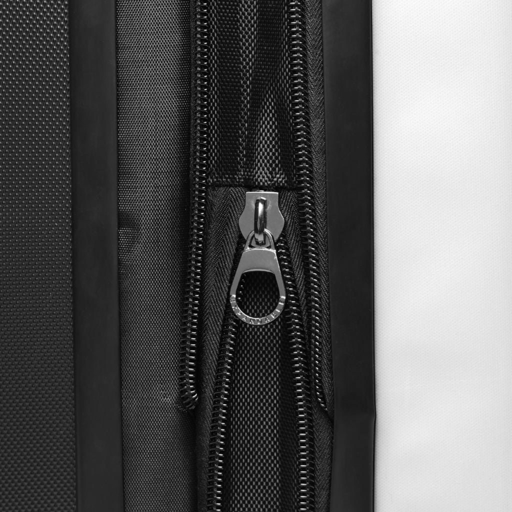 Close-up of a black suitcase zipper on a textured surface.