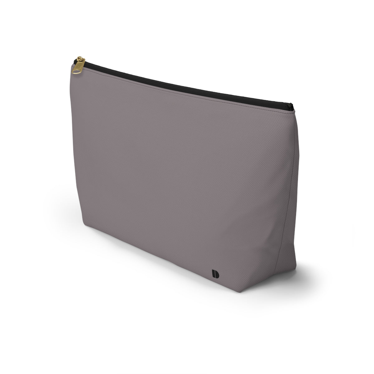 A minimalist makeup pouch in a muted gray  color, featuring a gold zipper pull and a small black monogram logo on the bottom right, set against a plain white background.