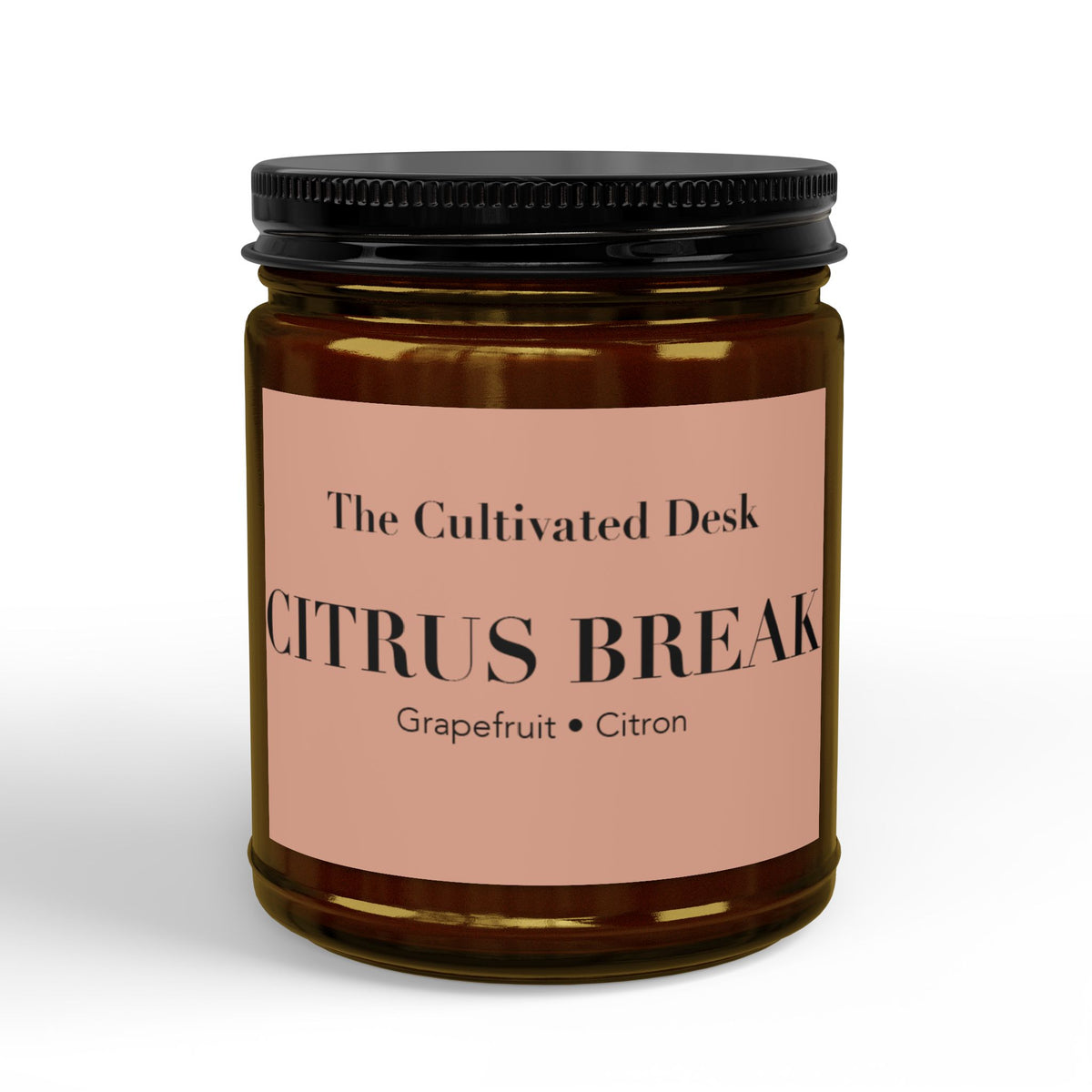 Refreshing scented candle in a 9oz amber glass jar featuring a minimalist dusty pink label with the text "The Cultivated Desk," "CITRUS BREAK," and scent notes "Grapefruit • Citron" in black serif typography, sealed with a ribbed black metal lid. Scented candle titled 'Citrus Break', available in 9oz and 4oz sizes.