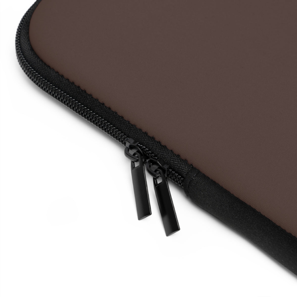 Close-up of dark brown laptop sleeve and dual zipper pulls against a white background