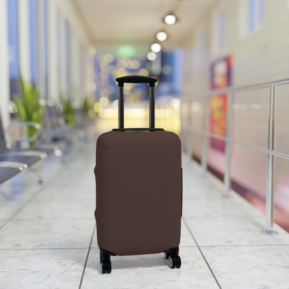 A brown protective luggage cover fitted on a rolling suitcase, set in a blurred airport terminal hallway.