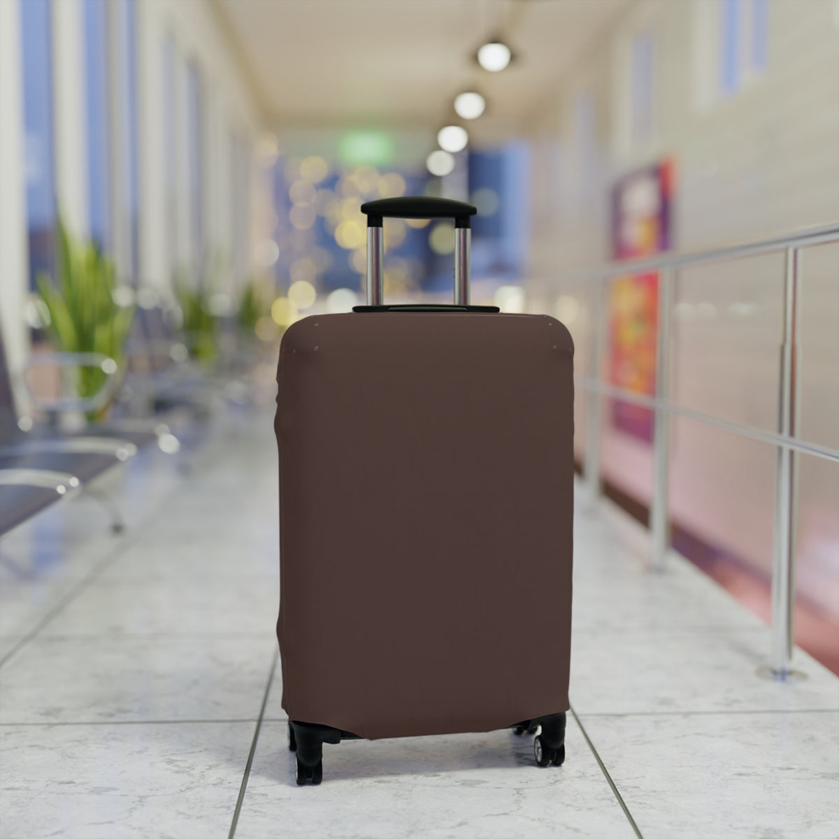 A brown protective luggage cover fitted on a rolling suitcase, set in a blurred airport terminal hallway.