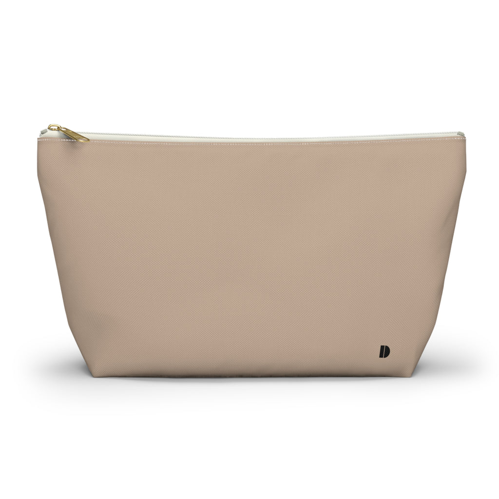 A beige zippered pouch with a small black monogram logo on the bottom right corner, photographed on a clean white background.