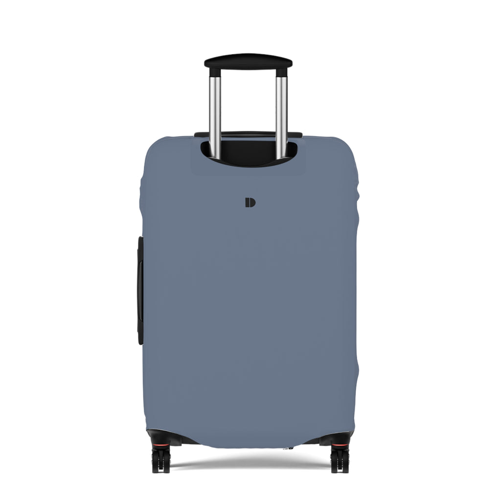 A slate blue luggage cover fitted over a rolling suitcase, shown from the front on a clean white background. The cover has a small black monogram logo near the top center and a black telescoping handle.