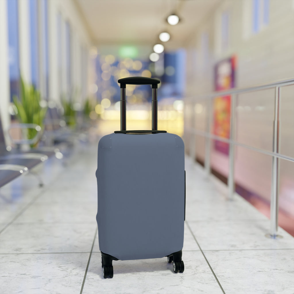 A light blue protective luggage cover fitted on a hard-shell suitcase with an extended telescoping handle and four wheels, standing upright in a brightly lit airport terminal corridor.