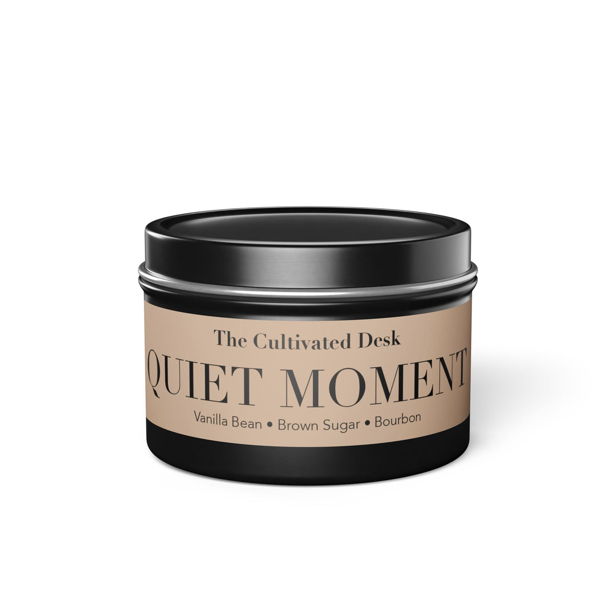 A black metal tin candle with a beige label reading 'The Cultivated Desk QUIET MOMENT Vanilla Bean • Brown Sugar • Bourbon' on a white background.