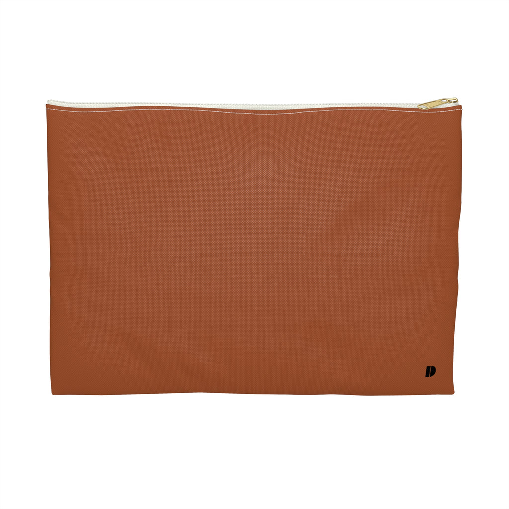 A rectangular rust-colored pouch with a gold zipper and a small black monogram logo in the bottom right corner, set against a plain white background.