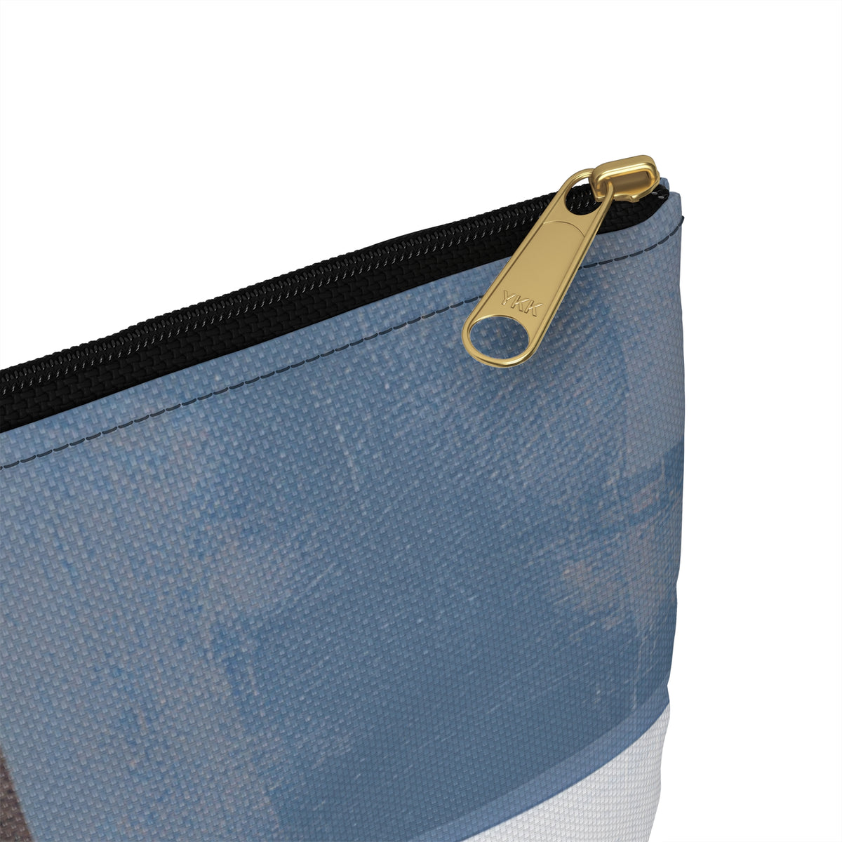 Close-up of a blue patterned zippered pouch with a black zipper and a gold metal pull tab on a white background.
