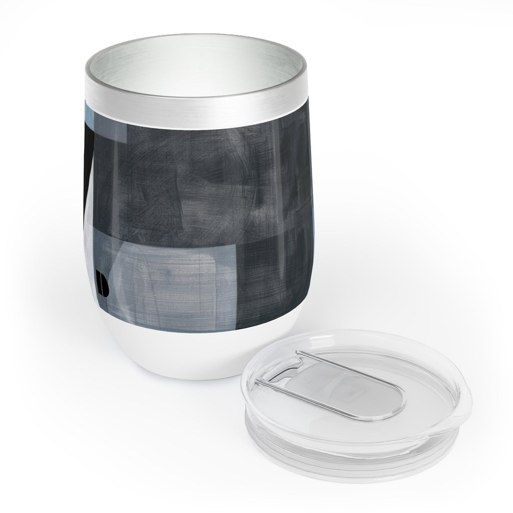A stainless steel insulated tumbler with a clear lid, featuring a modern abstract geometric pattern in shades of gray, black, and white on the body.
