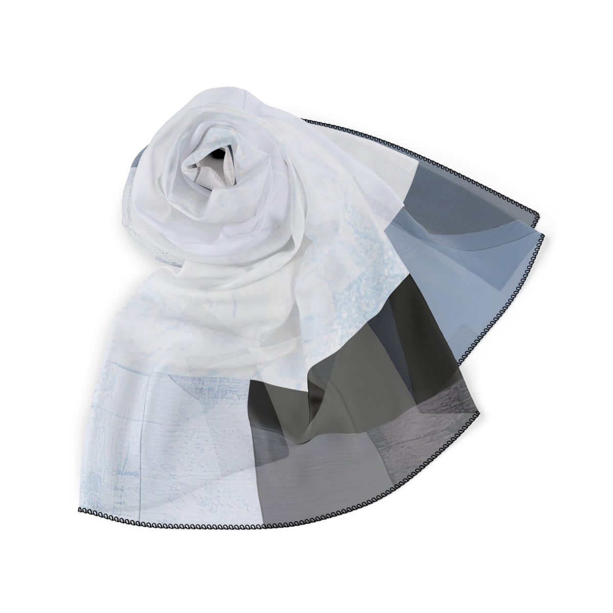 A lightweight sheer scarf with a patchwork design in white, light blue, gray, and charcoal, styled in a loose roll on a solid white background.