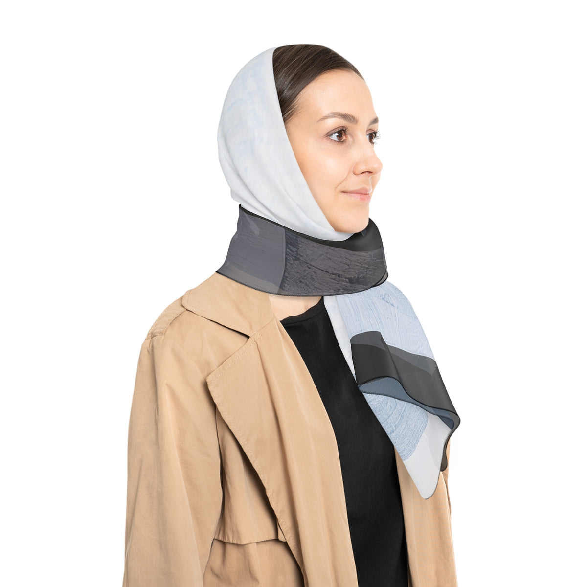 A woman wearing a light blue and gray wrap as a head scarf with a dark gray neck support band, styled with a beige trench coat over a black top, against a solid white background.