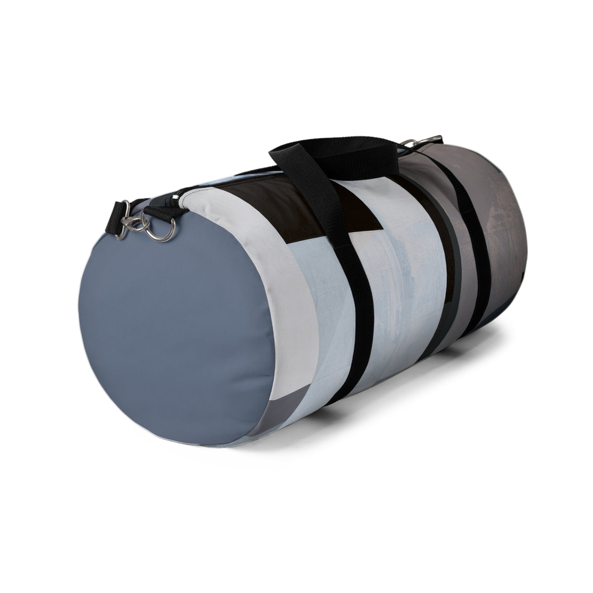 A cylindrical duffel bag with a modern abstract color-blocked pattern in slate blue, white, gray, and black, featuring black carrying handles and a metal D-ring on a white background.