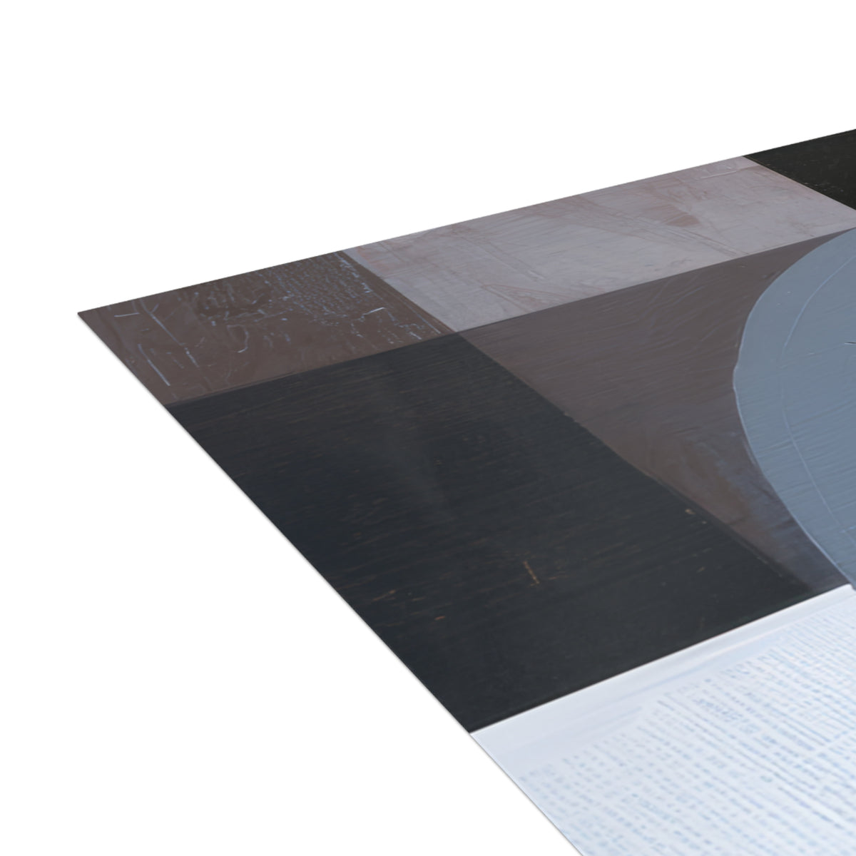 A close-up of a corner of a correspondence card with an abstract design in black, gray, brown, and white, partially overlapping a white textured surface on a white background.