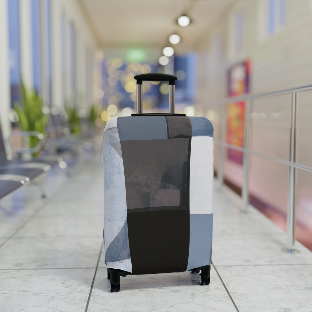 A hard-shell carry-on suitcase with an extendable handle and spinner wheels, covered in a patchwork-patterned luggage sleeve. The sleeve features a geometric design in shades of slate blue, charcoal gray, black, and off-white.