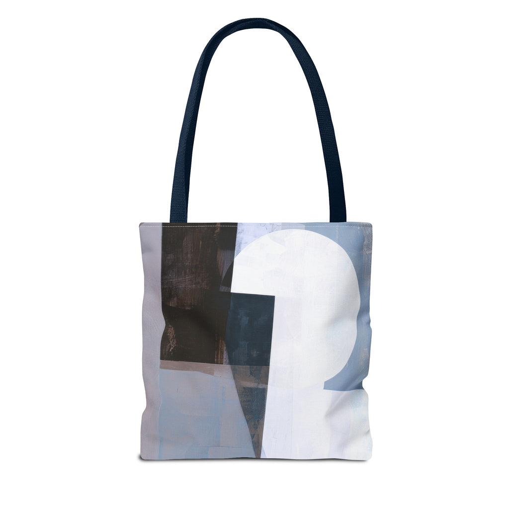A canvas tote bag with dark navy blue shoulder straps, featuring an abstract collage print on the front with light blue, white, and dark gray blocks.