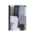 A passport cover featuring an abstract geometric pattern in shades of blue, gray, white, and black, with a solid black spine band.