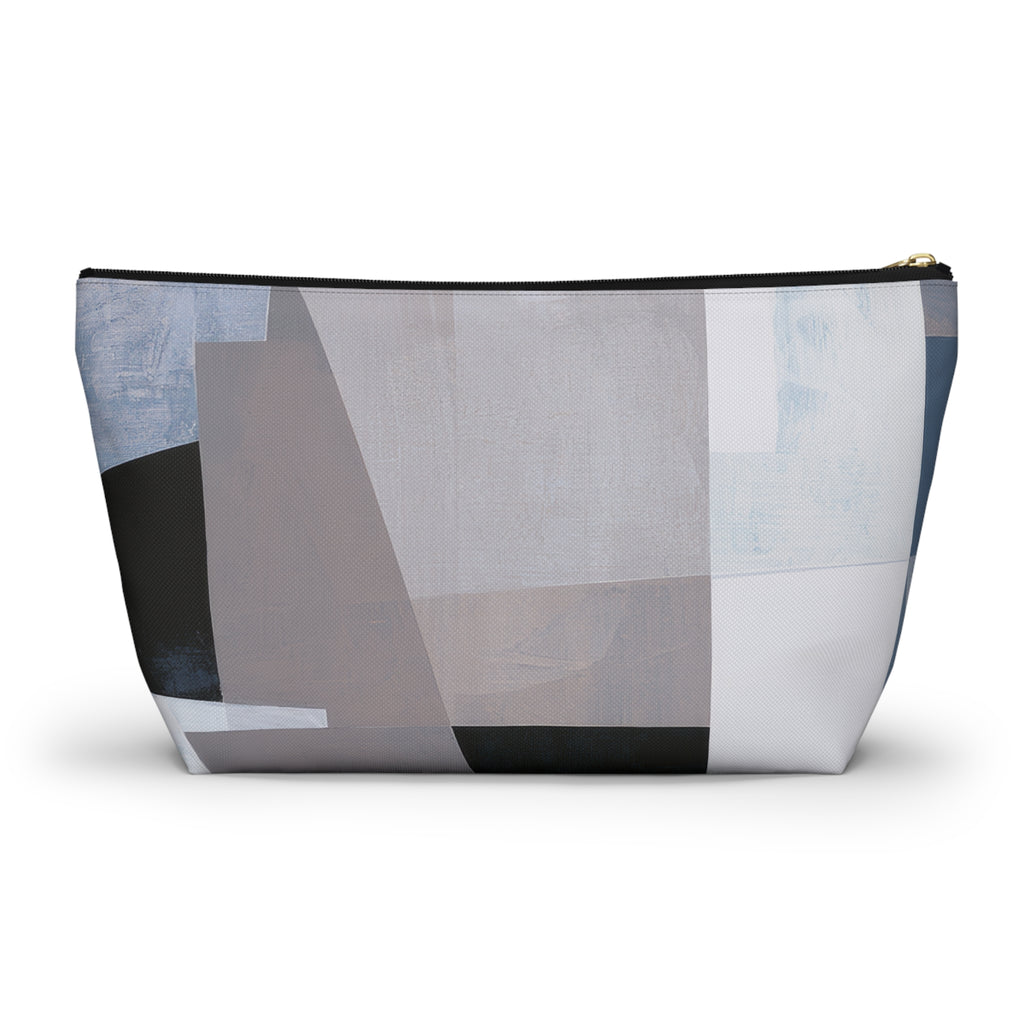 A zippered cosmetic pouch with an abstract geometric print in shades of gray, white, black, and light blue, shown on a plain white background.