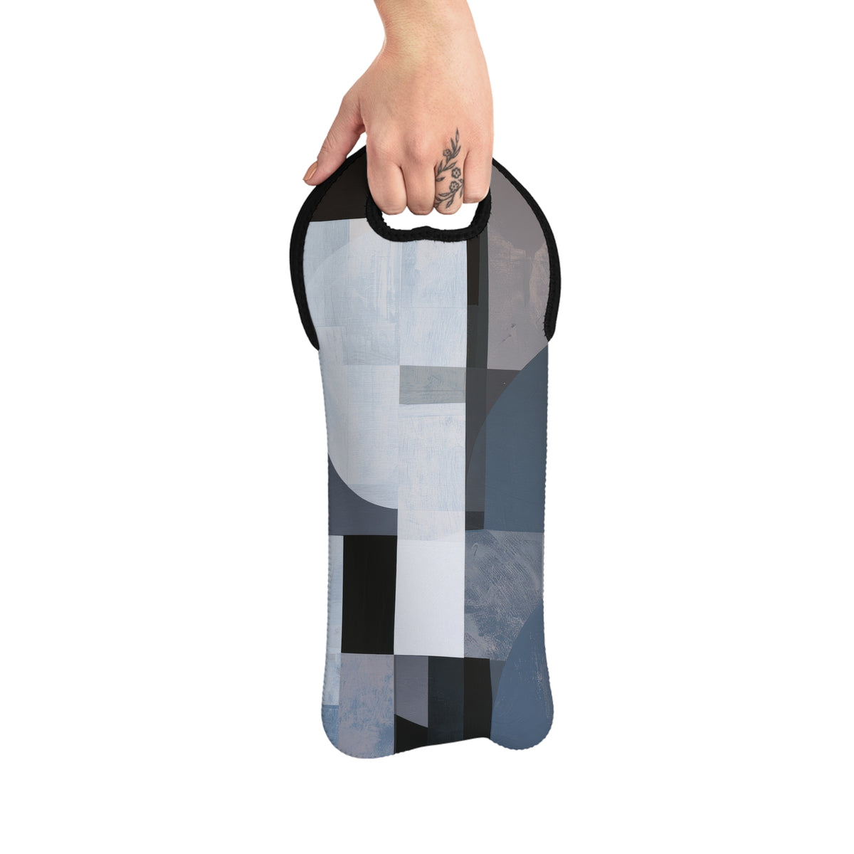 A hand holding a slim, flexible wine tote with a geometric abstract print in shades of blue, gray, white, and black, set against a plain white background.