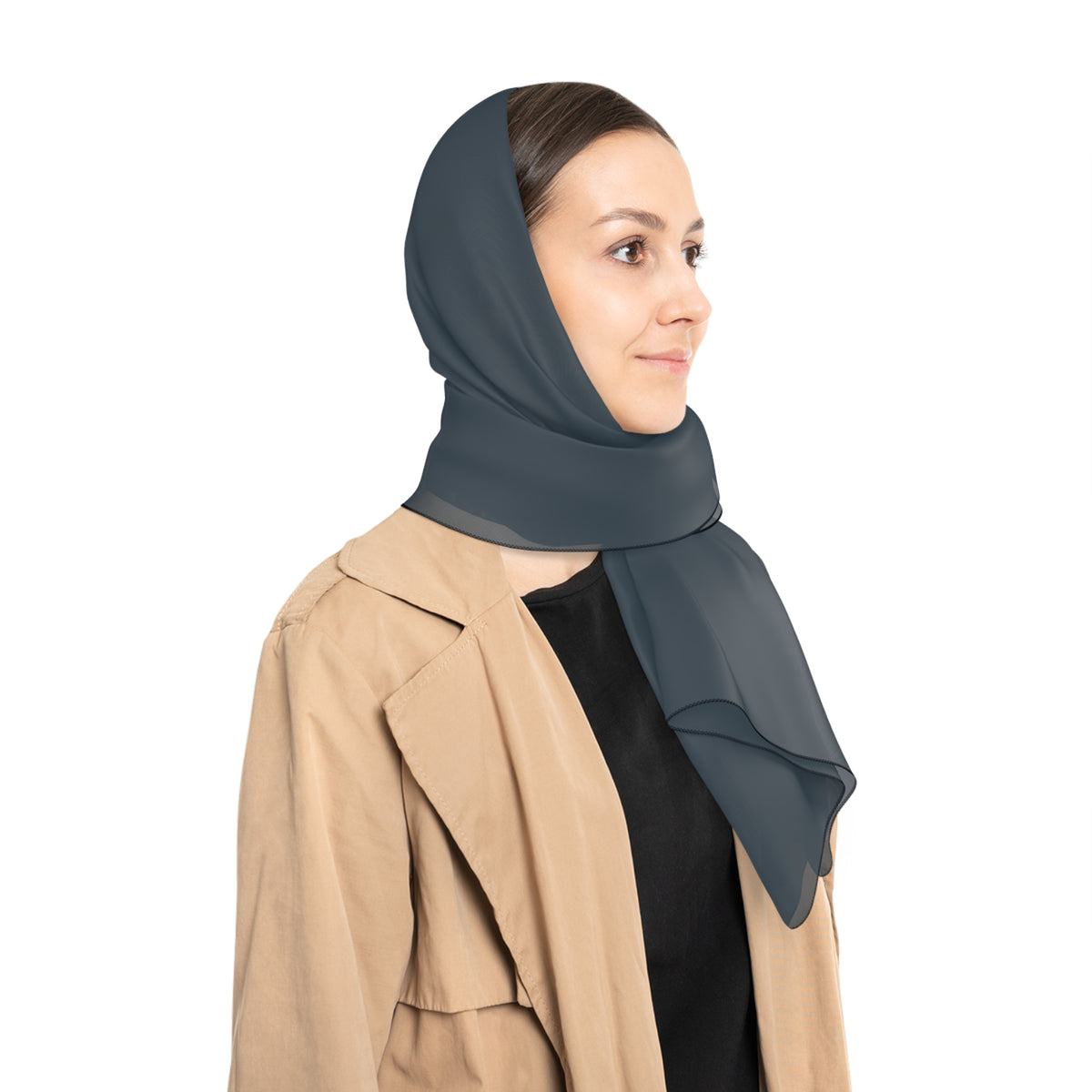 A woman wearing a dark slate gray wrap as a head scarf and a beige trench coat over a black top, shown in profile against a solid white background.