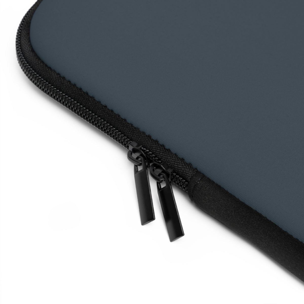 Close-up of slate blue laptop sleeve and black zipper on a white background