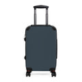 A dark slate blue hard-shell suitcase with an extended telescoping handle and four spinner wheels, shown from a front-facing angle on a solid white background.