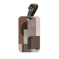 A rectangular luggage tag with rounded corners featuring an abstract geometric pattern in earthy tones of brown, beige, and mauve. It has a black leather strap with a gold-tone metal buckle at the top, shown against a plain white background.
