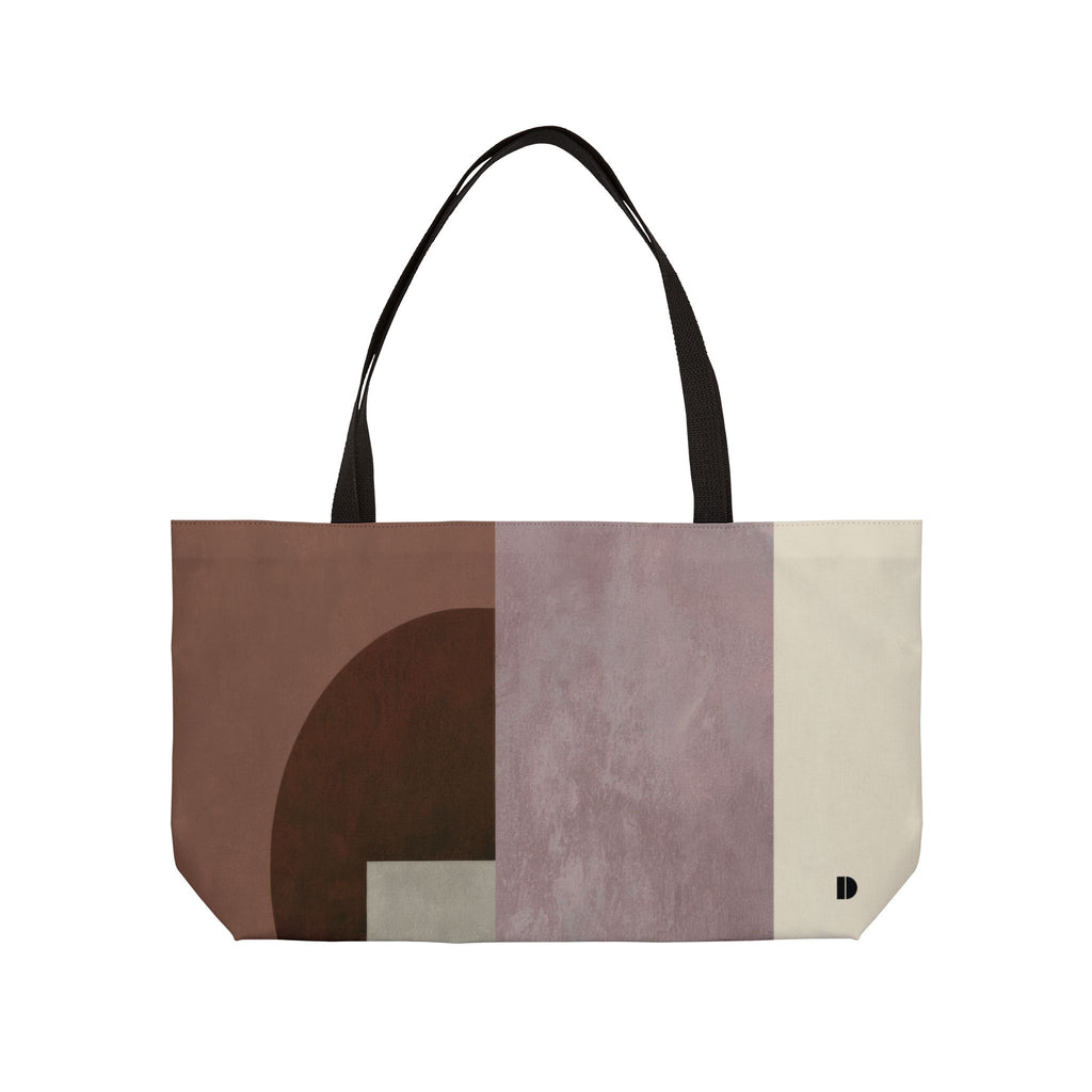 A tote bag with a geometric color-blocked pattern in earthy tones of brown, beige, gray, and terracotta, featuring black shoulder straps, shown against a plain white background.