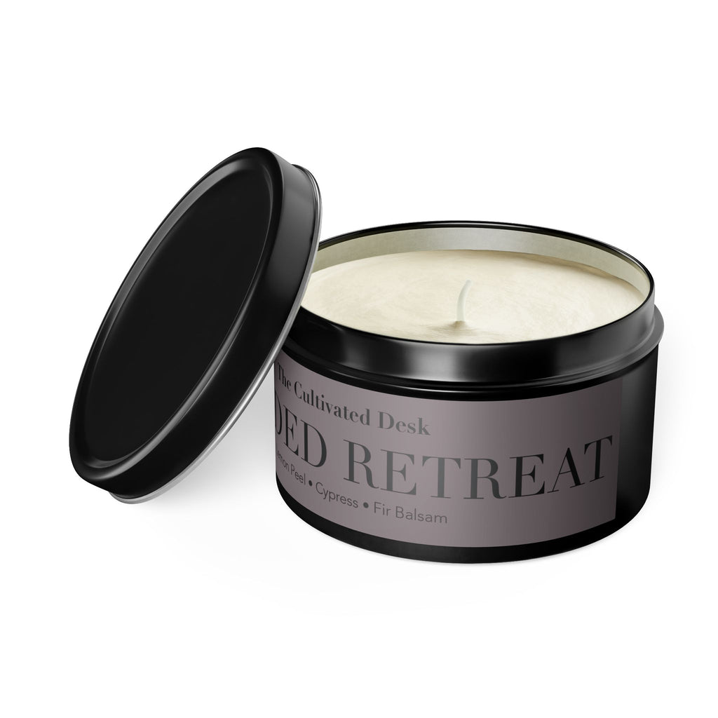An open black metal tin candle with cream-colored soy wax, shown on a clean white background. The label reads 'The Cultivated Desk' and 'WOODED RETREAT'.